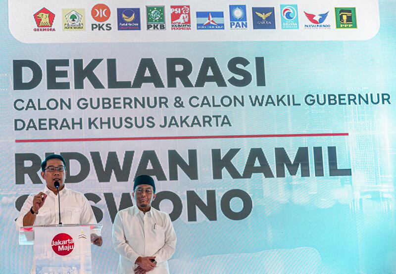 Ridwan Kamil (kiri), calon gubernur Jakarta, dan pasangannya Suswono (kanan) mendeklarasikan pencalonan mereka di panggung dengan latar belakang yang menampilkan logo 12 partai politik yang mendukung mereka, di Jakarta pada 19 Agustus 2024. [Eko Siswono Toyudho/BenarNews]