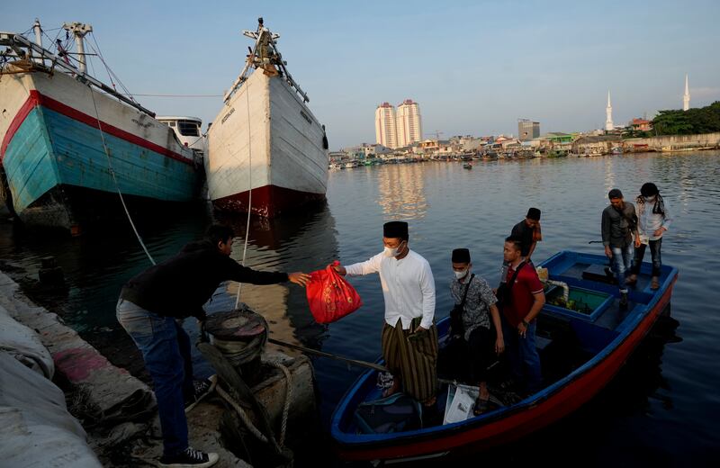 Warga tiba dengan perahu untuk mengikuti salat Idul Fitri di pelabuhan Sunda Kelapa di Jakarta, 2 Mei 2022. [AP]