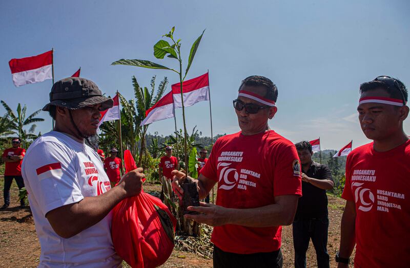 Komandan Operasi Madago Raya, Kombes. Pol. Boy FS Samola (kanan) memberikan secara simbolis bantuan sembako dan bibit tanaman kepada salah satu eks-narapidana terorisme seusai pembentangan bendera Merah Putih di kaki Gunung Biru, Desa Pantangolemba, Kecamatan Poso Pesisir Selatan, Poso, Sulawesi Tengah, Sulawesi Tengah, Jumat, 16 Agustus 2024. [Taufan Bustan/BenarNews]