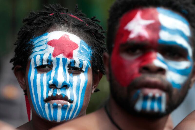 Aktivis Papua mewarnai muka mereka dengan warna lambang Bintang Kejora, simbol gerakan separatis Organisasi Papua Merdeka, saat berdemonstrasi di dekat Istana Negara di Jakarta, 22 Agustus 2019. (AP)