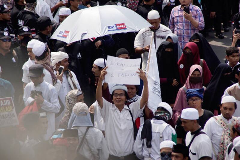 Seorang warga mengangkat poster ketika ikut aksi unjuk rasa di depan Bareskrim Polri, Jakarta, 6 April 2018. (Arie Firdaus/BeritaBenar)