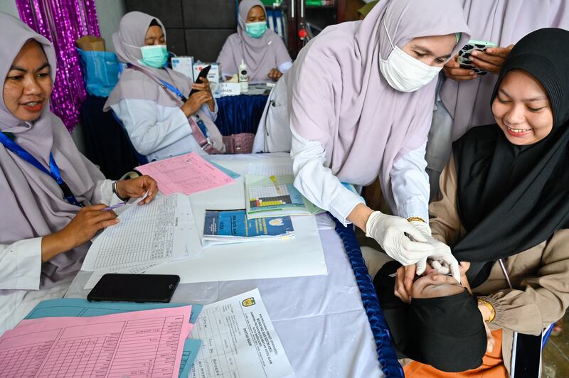 Seorang bayi menerima kapsul polio saat program pencegahan stunting di pos pelayanan terpadu di Banda Aceh, 14 November 2022. [Chaideer Mahyuddin/AFP]
