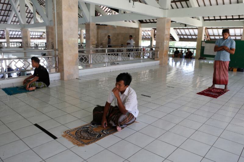 Warga Muslim melakukan jaga jarak sosial sebagai pencegahan penularan COVID-19 ketika melakukan shlat Jumat di sebuah mesjid di Bali, Indonesia, pada 20 Maret, 2020. (AP)