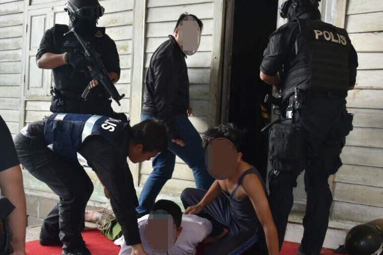 Polis Malaysia mengaburkan wajah di dalam gambar yang menunjukkan pegawai anti-keganasan menangkap suspek yang dipercayai menyokong militan Negara Islam, di satu lokasi rahsia.