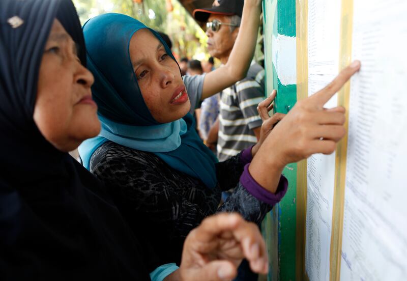 Residents look for their names on a list at a polling center at an elementary school in Sultan Kudurat, Maguindanao province, southern Philippines, as they prepare to vote in a referendum to ratify a law that would give Muslims autonomy in the region, Jan. 21, 2019. [Jeoffrey Maitem/BenarNews]