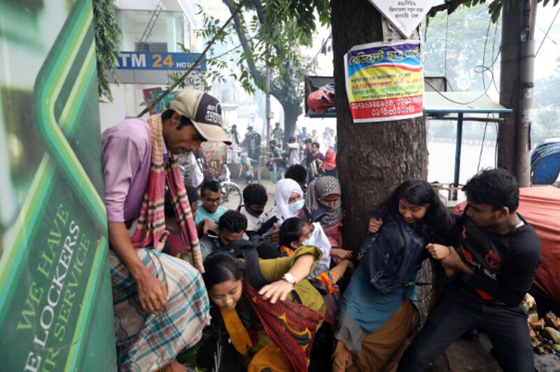 Protesters run as police fire tear gas shells in Dhaka, Aug. 5, 2018. (Reuters)