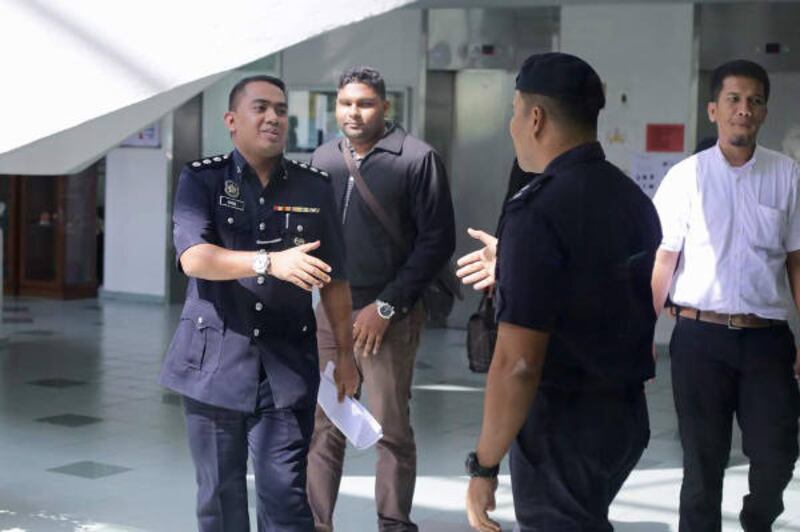 Wan Azirul Nizam Che Wan Aziz (kiri), penyidik kasus pembunuhan Kim Jong-nam, meninggalkan Pengadilan Tinggi di Shah Alam setelah bersaksi dalam persidangan terhadap dua perempuan yang didakwa membunuh Kim Jong-nam, 25 Oktober 2017.