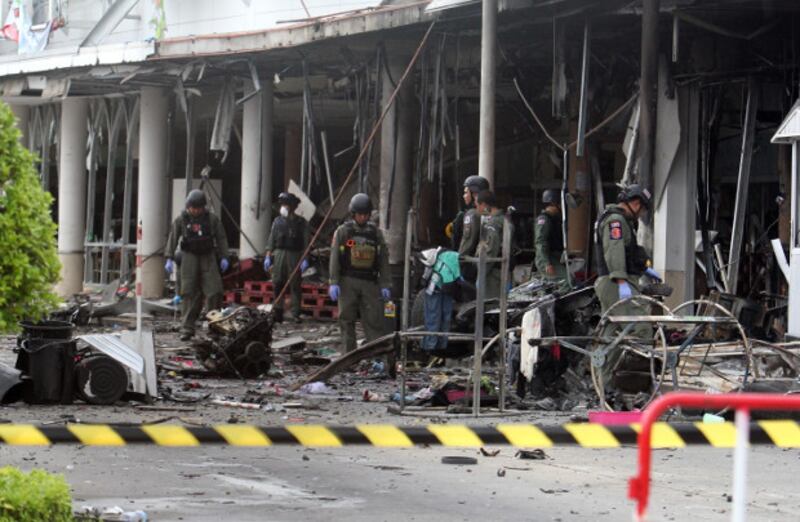 Bomb disposal officers comb the scene of a car-bombing that injured people at the Big C department store in Pattani town, southern Thailand, May 10, 2017. 