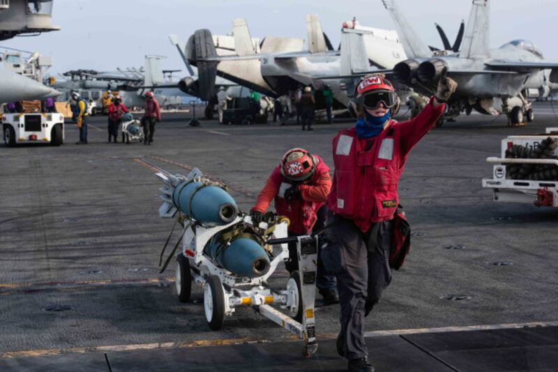 U.S. Navy men transfer bombs from a designated holding location to an aircraft on the flight deck of the U.S. aircraft carrier USS Ronald Reagan, near the disputed region of the South China Sea, Aug. 17, 2019. [Janweb B. Lagazo/U.S. Navy] 