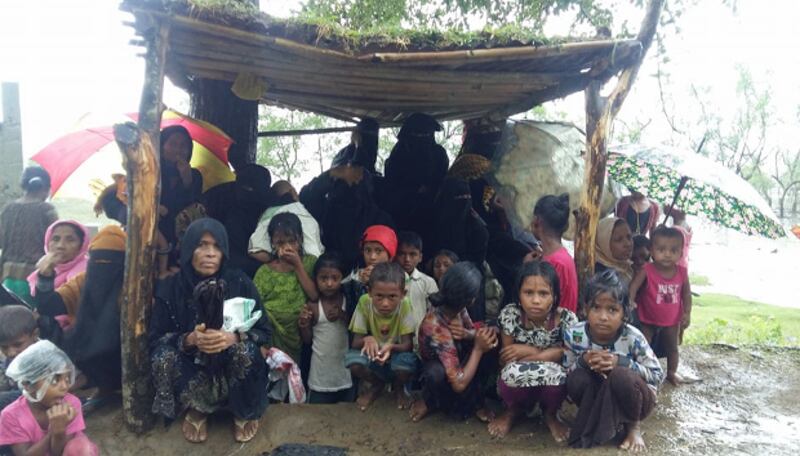 আশ্রয় না পেয়ে টেকনাফ নাইট্যং পাড়ার রাস্তার পাশে একটি ছাউনিতে বসে আছেন রোহিঙ্গারা। ২৮ সেপ্টেম্বর ২০১৭।