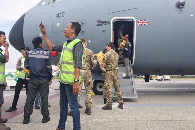 Indonesian military personnel unload aid from a British Air Force cargo plane at the Sepinggan airport, in Balikpapan, East Kalimantan province, Oct. 5, 2018.