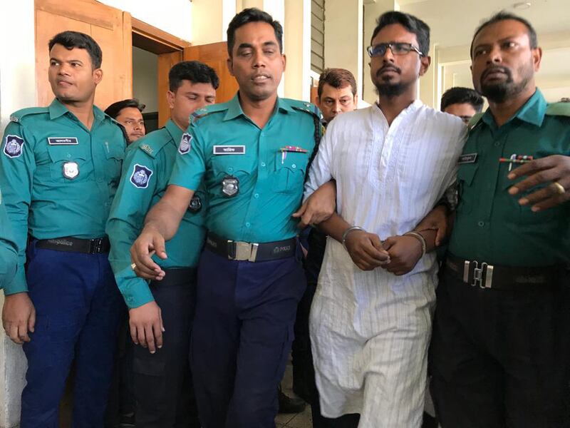 Bangladeshi police officers escort Shariful Islam (alias Khaled) out of an anti-terrorism court in Dhaka after a judge sentenced him and six other defendants to death for the Holey Artisan café attack, Nov. 27, 2019.
