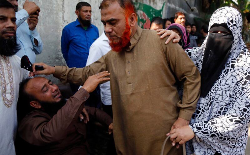 Relatives console a man after a massive fire killed at least 67 people in Dhaka's Chawkbazar neighborhood, Feb. 21, 2019. [Megh Monir/BenarNews]