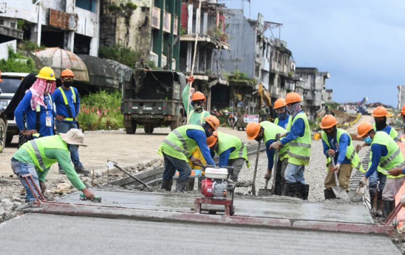 Workers pour cement along Quezon Avenue as part of efforts to rebuild streets and other infrastructure in war-torn Marawi, Oct. 17, 2020. [Froilan Gallardo/BenarNews]