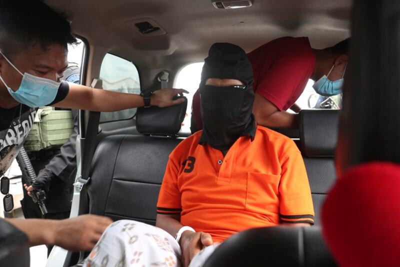 Polisi mengawal tersangka militan Zulkarnaen (tengah), yang juga dikenal sebagai Aris Sumarsono, setibanya di Bandara Internasional Soekarno-Hatta di Tangerang, Banten, 16 Desember 2020. [Achmad Ibrahim/AP]