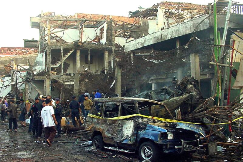 Polisi memeriksa reruntuhan bangunan yang hancur sehari setelah ledakan bom di Kuta, Bali, pada 13 Oktober 2002. Umar Patek, pembuat bom dalam aksi terorisme di Bali tahun 2002 yang menewaskan 202 orang itu, dibebaskan secara bersyarat pada Rabu, 7 Desember 2022, setelah menjalani setengah dari masa hukuman 20 tahunnya, meskipun ditentang oleh Pemerintah Australia yang warganya merupakan korban tewas terbanyak dalam serangan itu. [Foto AP, File]