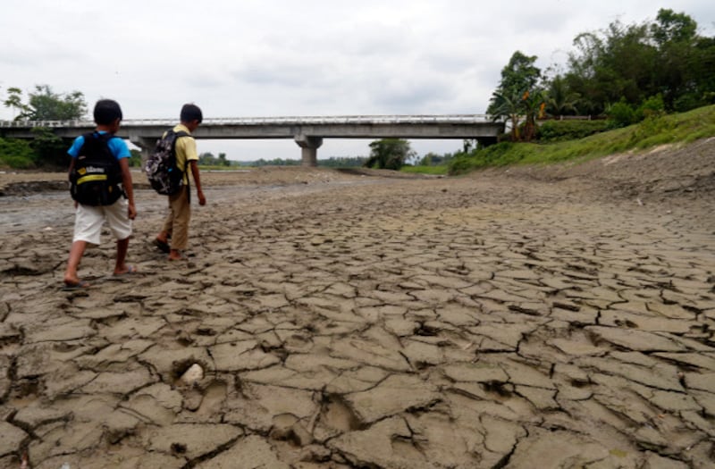 Children walk on a dried up river in Surallah town in the southern Philippine province of South Cotabato, March 29, 2019. [Jeoffrey Maitem/BenarNews]