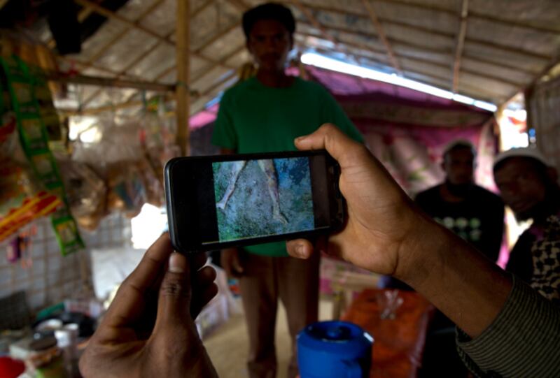 Refugee Mohammad Karim shows his cellphone video of mass grave he found in Myanmar before he fled to Bangladesh, Jan. 14, 2018.