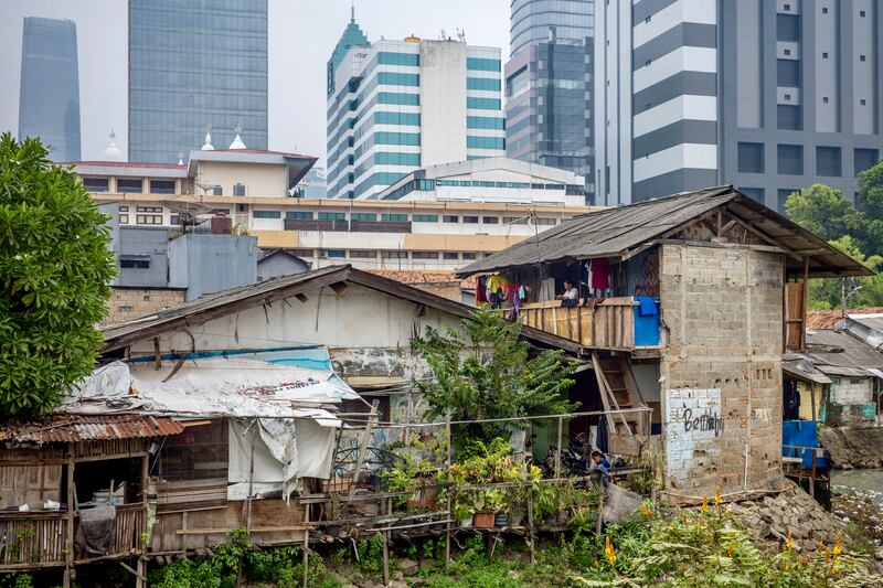 Beberapa rumah sangat sederhana dengan latar belakang kawasan bisnis Jakarta, 14 Mei 2024. [Bay Ismoyo/AFP]