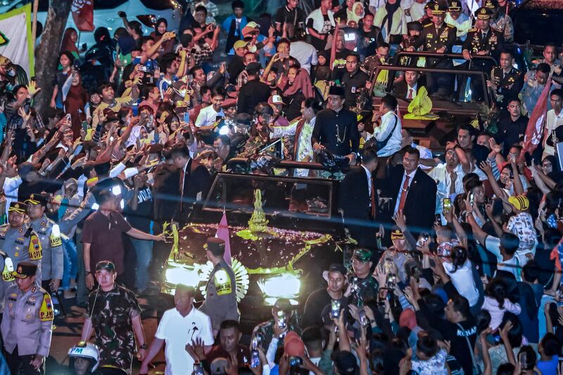 Mantan Presiden Indonesia Joko Widodo dan istrinya Iriana Jokowi (tengah) disambut oleh ribuan warga di kampung halamannya di Solo, Jawa Tengah, setelah mereka kembali dari Jakarta setelah masa jabatan kepresidenannya berakhir, 20 Oktober 2024. [Devi Rahman/AFP]