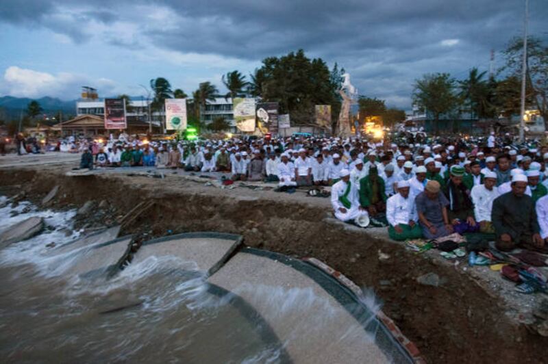 Muslims hold a mass prayer in Palu on October 12, 2018, following the September 28 earthquake and tsunami that killed 2,000 people and left thousands more missing, presumed dead. [AFP]