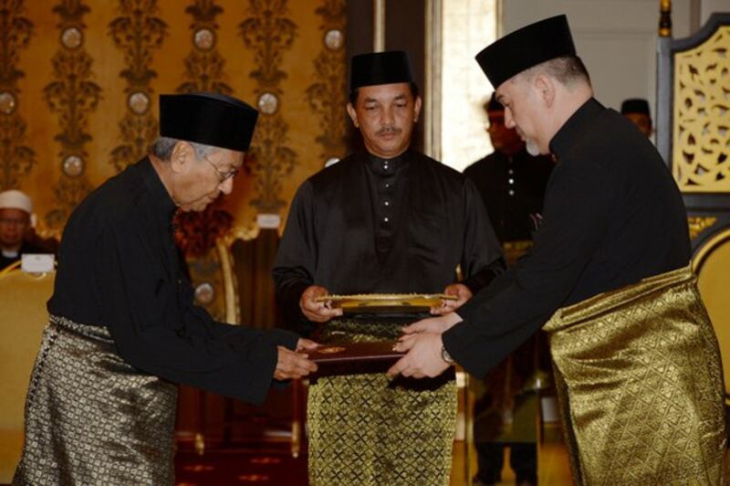 Mahathir Mohamad (left) is sworn in as Malaysia's seventh prime minister by Sultan Muhammad V, the nation's king, at the royal palace in Kuala Lumpur, May 10, 2018. [Bernama via Reuters]