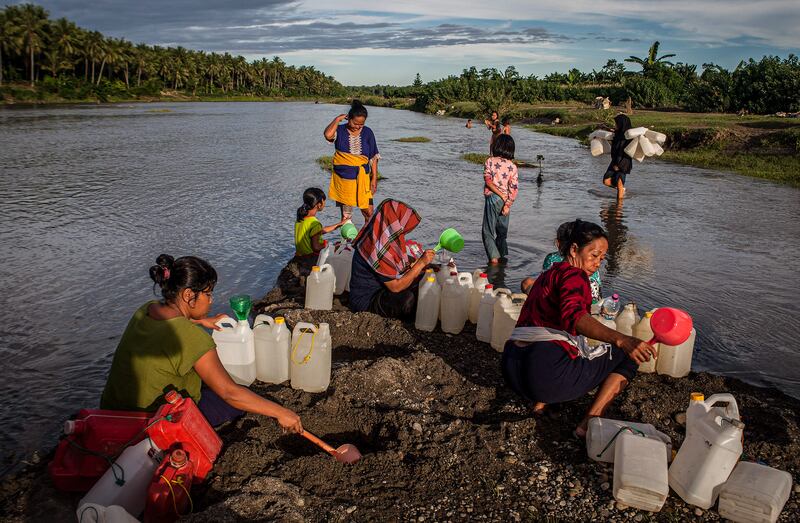 Sejumlah warga mengambil air bersih di mata air sungai Desa Renggeang, Kecamatan Limboro, Kabupaten Polewali Mandar, Provinsi Sulawesi Barat, 12 Mei 2022. Mayoritas warga yang mengambil air bersih di sungai ini adalah ibu-ibu. Menurut mereka, mengambil air bersih di sungai adalah tugas perempuan karena di saat sore hari suami-suami mereka punya pekerjaan di kebun. [Keisyah Aprilia/BenarNews]