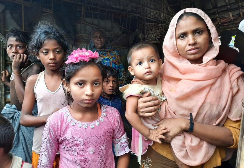 টেকনাফের বাহারছড়া শরণার্থী শিবিরে নিজের ঘরের সামনে মায়ের সঙ্গে দাঁড়িয়ে আছে নয় বছরের রোহিঙ্গা শিশু তসলিমা আকতার। ১৬ আগস্ট ২০২০।